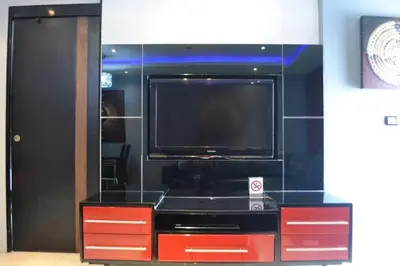 a living room with a tv and red cabinets at Absolute bangla suites 65 sqm with Jacuzzi in Patong Beach