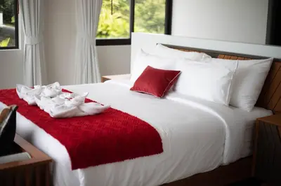 a large white bed with two white shoes on it at \u9759\u6e7e\u4e4b\u8679VILLA SHOOWA Cape Yamu\u5962\u534e\u6d77\u666f\u522b\u5885 in Ban Bang La