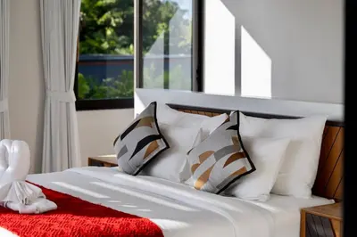 a bed with white pillows and a red blanket at \u9759\u6e7e\u4e4b\u8679VILLA SHOOWA Cape Yamu\u5962\u534e\u6d77\u666f\u522b\u5885 in Ban Bang La