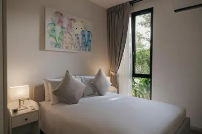 a bedroom with a white bed with a window at Halo 1 Title Naiyang beach in Phuket Town