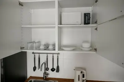 a kitchen with white cabinets and a sink and utensils at Halo 1 Title Naiyang beach in Phuket Town