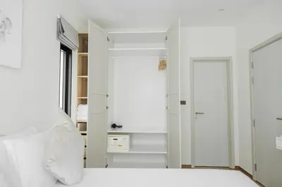 a bedroom with white walls and a door to a closet at Halo 1 Title Naiyang beach in Phuket Town