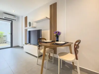 a dining room with a table and chairs and a television at Garden View Apartment 1BR - NV-103 in Chalong