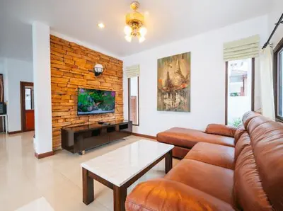 a living room with a couch and a tv at Pool Villa Tambon Patong in Patong Beach