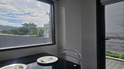 a dining room with a table and chairs and a window at Island Escape 1BR T1-206 in Chalong