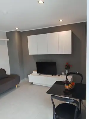 a living room with a table and white cabinets at Large Corner Apartment 1BR - NV-207 in Chalong