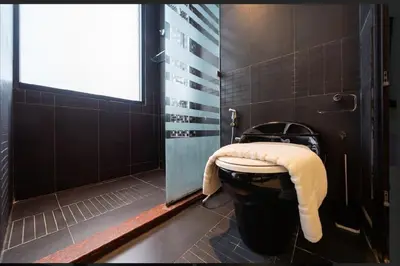 a bathroom with a toilet with a towel on it at Studio Apartment in Bangla Rd in Patong Beach