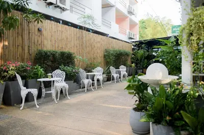 a row of white chairs and tables in a garden at Little Home Ao Nang in Ao Nang Beach