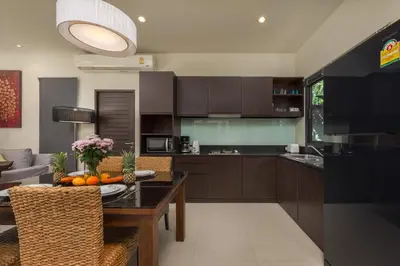 a kitchen with a table and a dining room at Saiyuan Estate by TropicLook in Rawai Beach