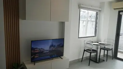 a living room with a tv and a table with chairs at Big Buddha View Apt-1BR T1-306 in Chalong