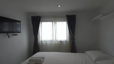 a bedroom with a bed and a window with a television at Boutique Comfort 1BR T2-410 in Chalong