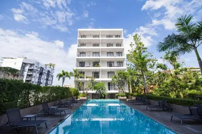 a hotel with a swimming pool in front of a building at Modern & Cozy Apartment 1BR - NV-413 in Chalong