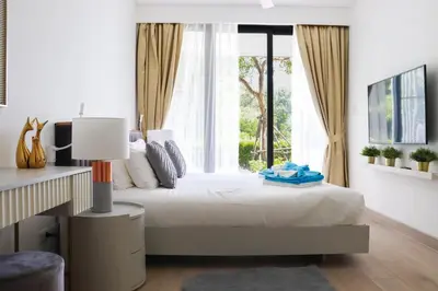 a bedroom with a bed with a large window at Cassia 3BR with Terrace Sea view apt by NLA in Phuket Town