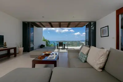 a living room with a couch and a table at Panoramic Sea View Luxury Apartment - Leelawadee21 in Kata Beach
