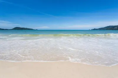a beach with the ocean and the sand at Patong Station House in Patong Beach