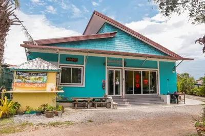 a blue house with a bench in front of it at OYO 902 Life and Love Resort in Ban Khlong Haeng