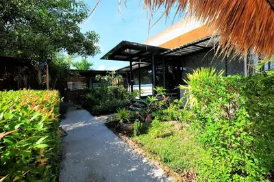 a walkway leading to a house with plants at OYO 503 Phuket Numnoi in Surin Beach