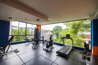 a gym with tread machines and a large window at 1BR Apartment near Villa Market - NV-423 in Phuket Town