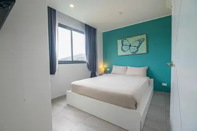 a bedroom with a bed with a butterfly picture on the wall at Modern & Stylish Apartment-2BR - NV-518 in Phuket Town