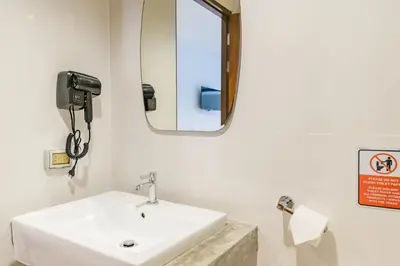 a bathroom with a white sink and a mirror at De Blue Sea Rawai Hotel in Ban Saiyuan (1)