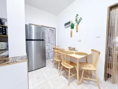 a kitchen with a table and a stainless steel refrigerator at Sea Dreamer Ao Yon Beach House in Ban Ao Makham