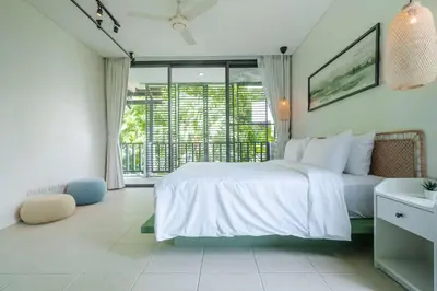 a bedroom with a white bed and a large window at Stylish Penthouse at Bangtao Beach in Surin Beach