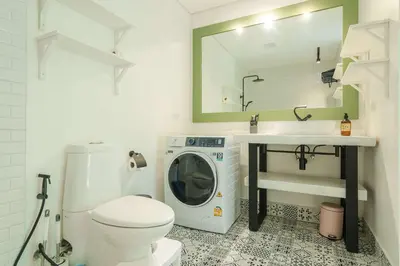 a bathroom with a washing machine and a sink at Stylish Penthouse at Bangtao Beach in Surin Beach