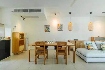a living room with a table and a couch at Stylish Penthouse at Bangtao Beach in Surin Beach