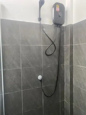 a shower in a bathroom with a phone on the wall at Suthida Resort in Rawai Beach