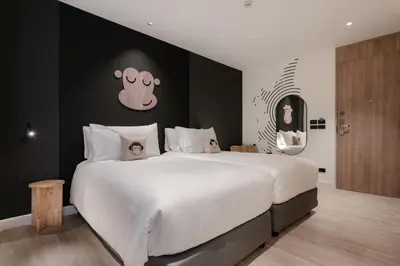 a bedroom with a large bed with a black wall at Blu Monkey Hub and Hotel Laguna, Bangtao Phuket in Bang Tao Beach
