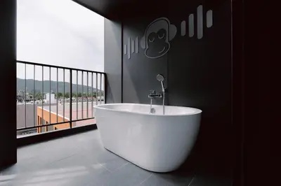 a bath tub in a room with a large window at Blu Monkey Hub and Hotel Laguna, Bangtao Phuket in Bang Tao Beach