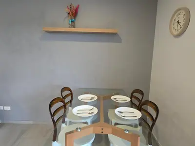 a dining room table with four chairs and a clock at Well located Apt 1BR - T2-421 in Chalong