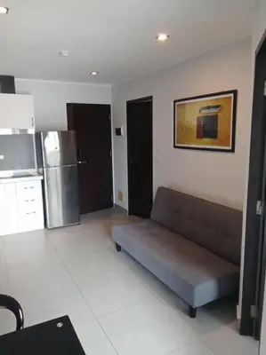 a living room with a couch and a refrigerator at Fully Furnished Apartment - NV-622 in Chalong