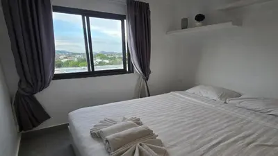 a bedroom with a white bed with towels on it at Urban loft 1BR T1-706 in Chalong