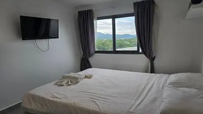 a bedroom with a bed and a flat screen tv at Urban loft 1BR T1-706 in Chalong