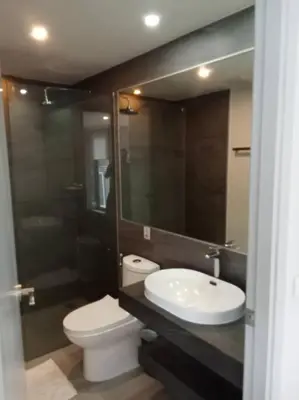 a bathroom with a sink and a toilet and a mirror at 2BR Aparment Near The Beach T2-717 in Phuket Town