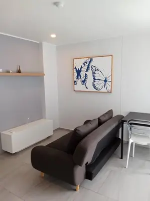 a living room with a couch and a table at Contemporary 1BR Condo - NV-724 in Phuket Town