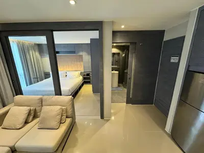 a living room with a couch and a bed at 1BDR Roof pool 500m to beach Great gym Parking in Kamala Beach