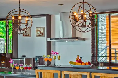 a kitchen with two chandeliers and a counter with fruit at Fully Serviced Grand Villa Luxury Time Phuket in Bang Tao Beach
