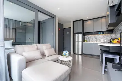 a living room with a white couch and a kitchen at Relax & Recharge in Modern Comfort at the Hill View Tropics Kamala Suite CTG L607 in Kamala Beach