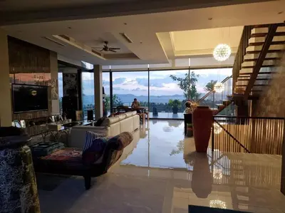 a living room with a couch and a view of the water at Krabi Glass House Sea View Villa in Tab Kaek Beach