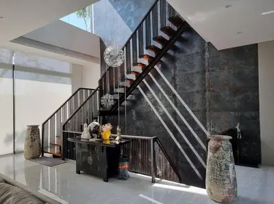 a living room with a staircase and a table with vases at Krabi Glass House Sea View Villa in Tab Kaek Beach