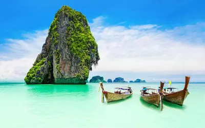 two boats in the water in front of a rock formation at XX BAO Pathong Beach เบา ป่าตอง บีช in Patong Beach