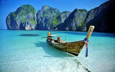 a boat sitting in the water on a beach at XX BAO Pathong Beach เบา ป่าตอง บีช in Patong Beach