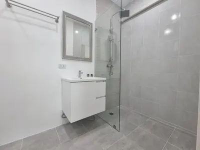 a white bathroom with a sink and a shower at Sanook villas Nai Harn beach in Rawai Beach