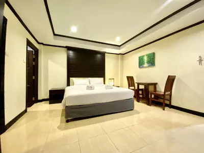 a bedroom with a bed and a table and chairs at Lucky Residence Patong in Patong Beach