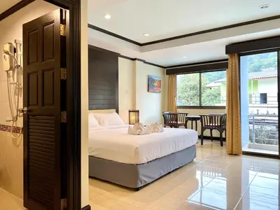 a bedroom with a bed and a balcony at Lucky Residence Patong in Patong Beach