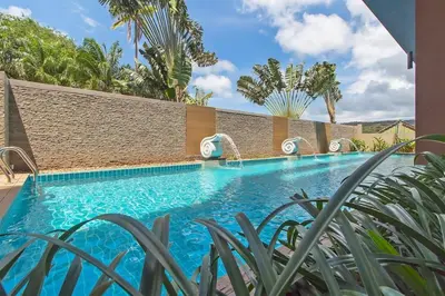 a swimming pool in a villa with palm trees at Cosy 1 bedroom Chic condo in Karon Beach