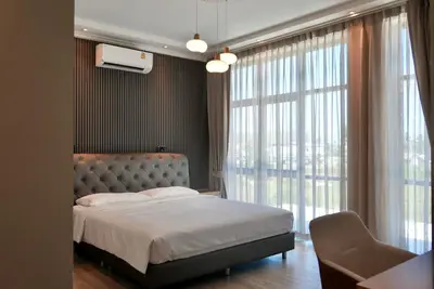 a bedroom with a bed and a large window at Phuket Villa Sofia in Ban Phak Chit