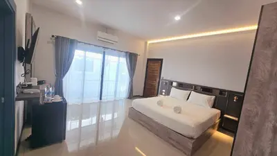 a bedroom with a bed and a large window at Smile Boutique at Saiyuan in Rawai Beach